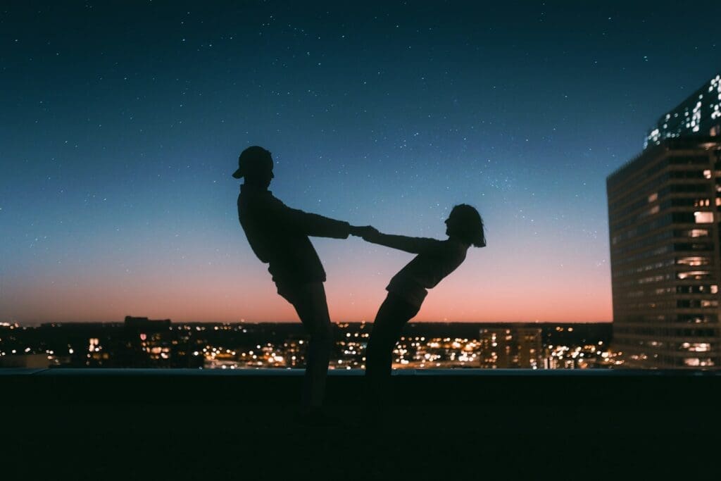 silhouette of two people against a city at dusk. love and dating can lead to new adventures 