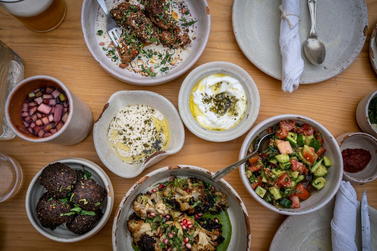 Photo by Alexandra Tran a wooden table topped with bowls of food