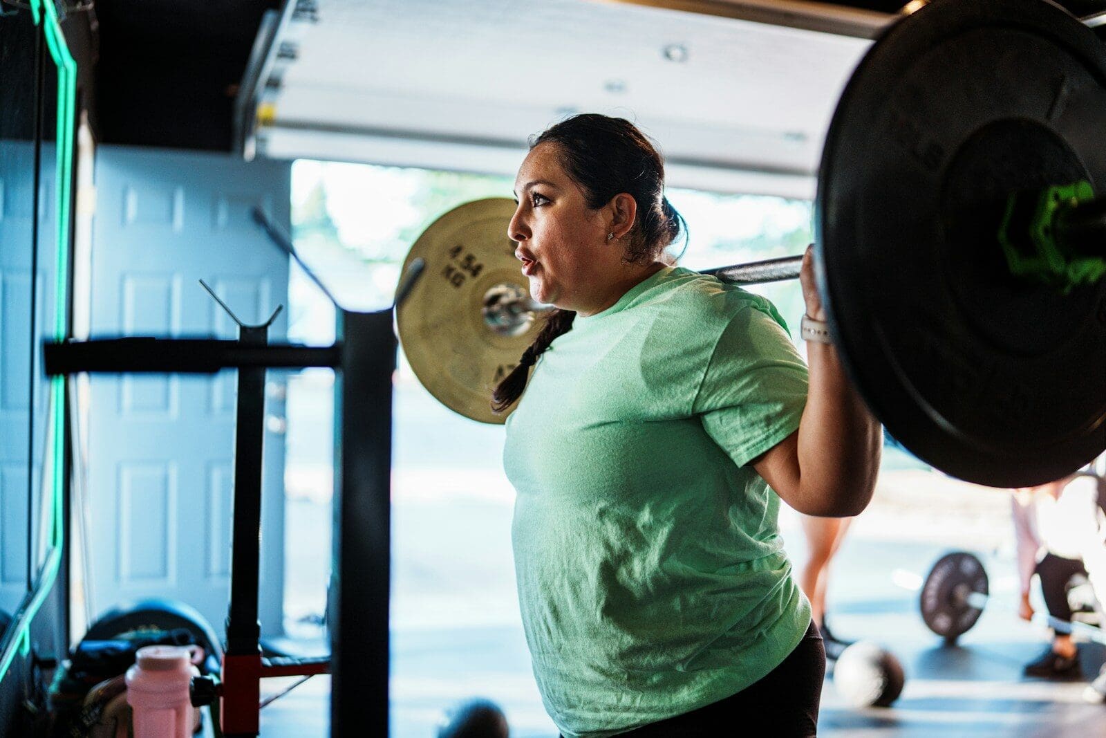 Woman lifting weights in a gym. You don't necessarily need to supplement with creatine but it can be a support to your active lifestyle