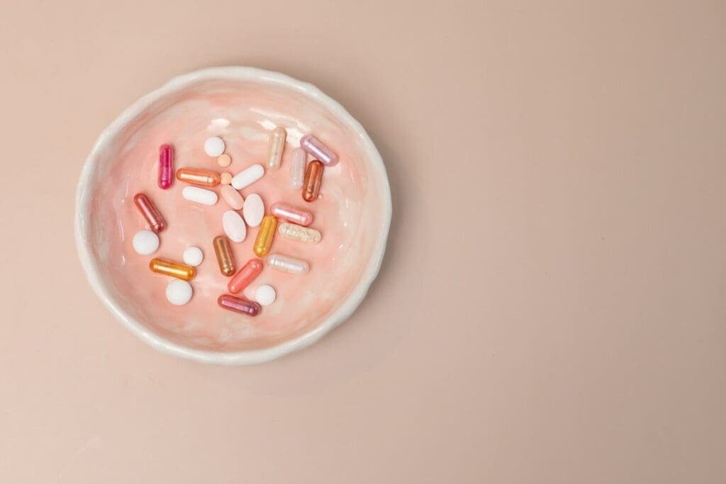 A white bowl filled with pills on top of a table. Natural herbal supplements are not automatically safe. 