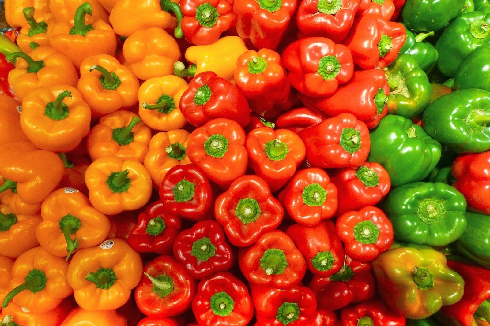 Photo by Nick Fewings orange red and green bell peppers massed together, peppers are an excellent source of vitamin C