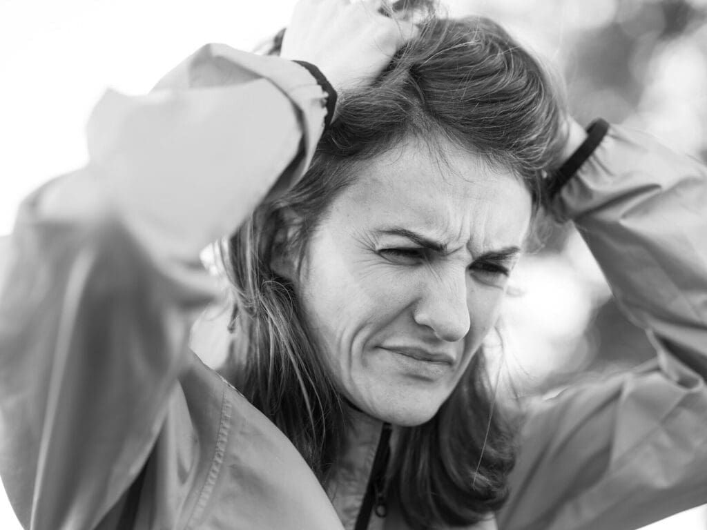 a woman holding her head in her hands. Perimenopause can be confusing